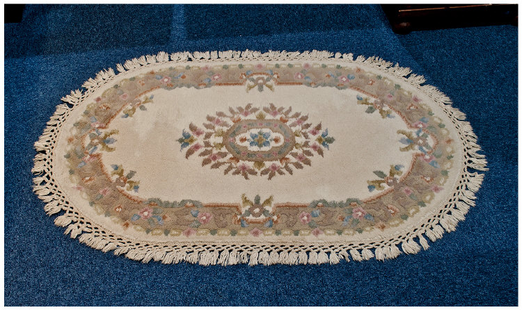 Modern Oval Wool Rug, floral decoration on beige ground. As new condition. 50 by 32 icnhes.
