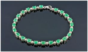 Silver Tennis Bracelet Set With Oval Cut Faceted Emeralds And 12 Diamond Chip Spacers, Length 8