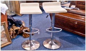 A Modern Pair of Cream Leather Seated and Chrome Bar Stools. Each stool 34 inches high.