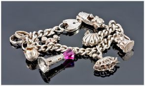A Silver Charm Bracelet loaded with 8 charms. Hallmarked. 52 grams.