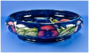 William Moorcroft Large Size Inverted and Footed Bowl. c.1920`s. ``Pansy`` design, on blue ground.