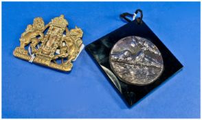 One Brass Chest Plaque together with a silvered metal plaque of a Volcano. In black glass frame.