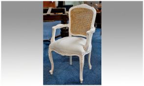 A Modern White and Gold Painted Bedroom Armchair, in the regency style wit caned lattice back.