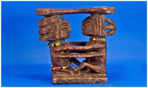 A Carved African Wood Figural Seat Or Head Rest. Depicting a female and male figure seated holding