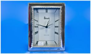 Harrods, A Silver Framed Mantle Clock, with green plush support. The Roman numeral face marked ``