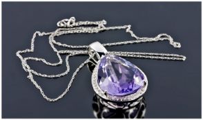 A 14ct White Gold And Diamond Pendant On Chain. Set with a pear shaped amethyst of excellent