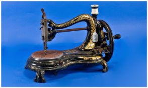 A Painted Cast Iron Shaped Victorian Sewing Machine by Jones, gilded highlights.