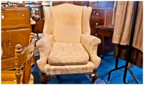 Georgian Style Wing Armchair, with padded upholstered wings and shaped rolling arms on carved