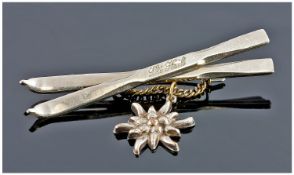 Silver Coloured Brooch In The Form Of Crossed Skis Marked Heil, With Sunburst Drop.