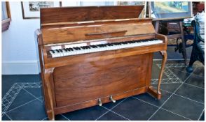 Kemble Minx Miniature Piano Of Fine Quality. Veneered in bare blonde walnut with two shaped