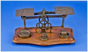 Pair Of Brass Postal Scales With Brass Weights, on shaped wooden base. Postal dates engraved to the