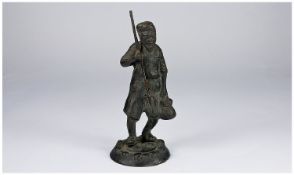 A 19th Century Oriental Small Bronze Figure. The man holding a fork in his right hand and a lidded