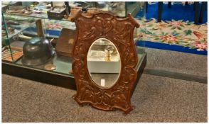 Art Nouveau Shaped And Carved Oak Mirror, with scroll corners carved with interlacing flowers and