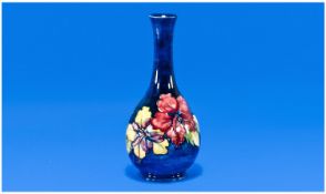 Moorcroft Signed Long Necked Vase. ``Hibiscus`` design, mixed colours on a blue ground. c.1940`s.