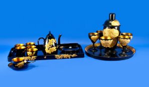 A Black And Gold Chinese Lacquered Tea Set, of tray, six cups and saucers, spoons and one lidded