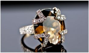 A 9ct Gold Smoky Quartz and Diamond Ring. The large single stone smoky quartz set with V shaped