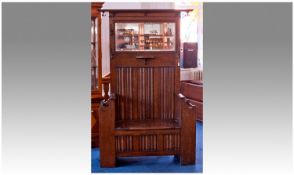 Oak Hallstand Of Typical Form With Panelled Back Bevelled Mirror, Hinged Seat And Coat Hooks.