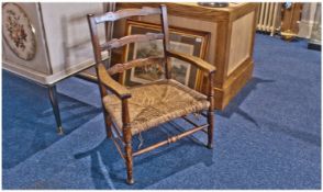 Edwardian Oak Wavy Back Rush Seated Low Back Armchair. On turned legs with cross stretchers, rush