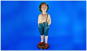 Early 20th Century Plaster Figure, of a young boy, wearing a green hat, cream top, blue shorts,
