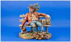 Capodimonte Figure of a Tramp on a Bench, signed Volta, a detailed and evocative piece showing a