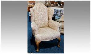 Queen Anne Style Wing Armchair, rolling arms, shaped top and sides, walnut cabriole legs, cream