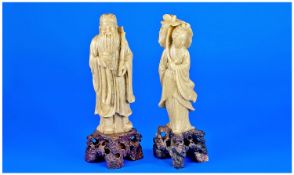 Chinese Green Soapstone Figures. A pair depicting a sage holding a bamboo branch, and a lady