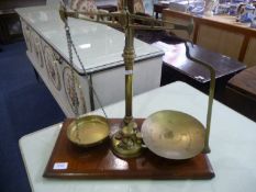 Brass Scales, raised on a wooden base, complete with weights.