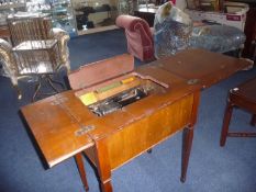 Early 20th Century Walnut Veneered Sewing Machine Table, enclosing a Singer sewing machine, raised