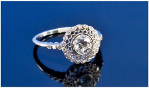 A Platinum Set Diamond Ring. The pave set single stone diamond of very good colour & bright/lively.