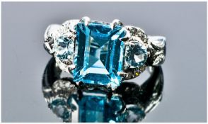 A Blue Topaz & White Sapphire Silver Set Dress Ring. The emerald cut blue topaz approximately 4cts