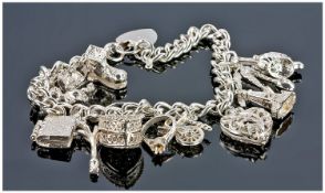 Silver Charm Bracelet, Loaded With 13 Charms, Complete With Padlock Fastener And Safety Chain.