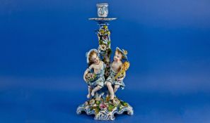 Late 19th Century German Figural Candlestick, decorated with blue floral scrollwork, with a Rococo