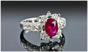 18 Carat Very Fine White Gold Ruby and Diamond Ring. The ruby of pigeon blood colour flanked by