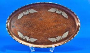 A Harold Holmes Arts and Crafts Oval Copper Tray overlaid with a pewter floral design and segments