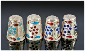 A Fine Set of Four Silver and Enamel Thimbles. Each decorated with circular and leaf shaped red and