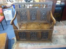 Victorian Oak Carved Box Settle, the crest with turned spindle gallery, elaborately carved panelled