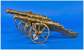 Pair of 20th Century Brass Model Cannons, the wooden frames with brass mounted edging.