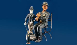 Charlie Chaplin Memorabilia with three figurines and one book. The largest is 22 1/2`` and seated,
