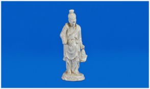 Blanc-de-Chine Figure of a Smiling Fisherman, dressed in a loose robe with a cloth, small bag and a