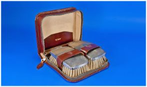 Leather Case Fitted with Two Silver Backed Brushes, with a silver mounted comb (Birmingham 1953).