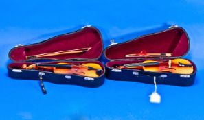 Two Miniature Cellos with bows in leatherette cases.
