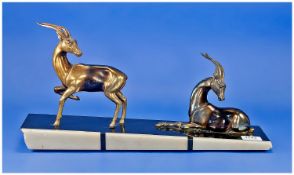 Art Deco Bronzed Spelter Gazelles, two, one seated, one standing, both with heads turned, looking
