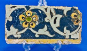 A Rare Safavid Cuerda Seca Fragmentry Pottery Wall Tile, Decorated with Flowers on a Blue Ground,