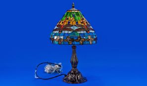 Tiffany Style Table Lamp, bronzed base, blue, orange and green glass shade. 19 inches in height.