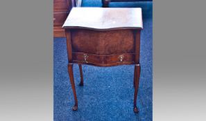 Early 20th Century Walnut Sewing Table, of serpentine form, the top lifting up, fitted with a