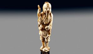 A Fine Quality Small Chinese Ivory Carving Of A Fisherman holding his catch of fish in one hand and