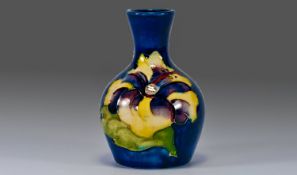 Moorcroft Small Vase ``Hibiscus`` Design on blue ground. Label to base reads Potters To Late Queen
