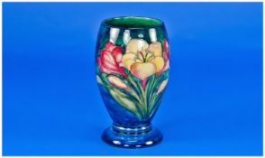 Moorcroft Small Footed Goblet Shaped Vase `Freesia` design on blue ground. 5 inches high.