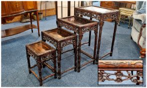 Chinese Padouk Nest of Four Tables, probably 19th century, all with panelled tops, foliage carved