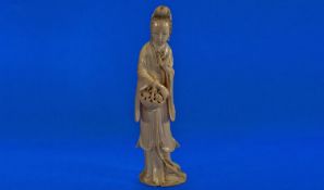 A Fine Quality Chinese One Piece Ivory Carving of Quan Yin holding a basket of flowers in one hand